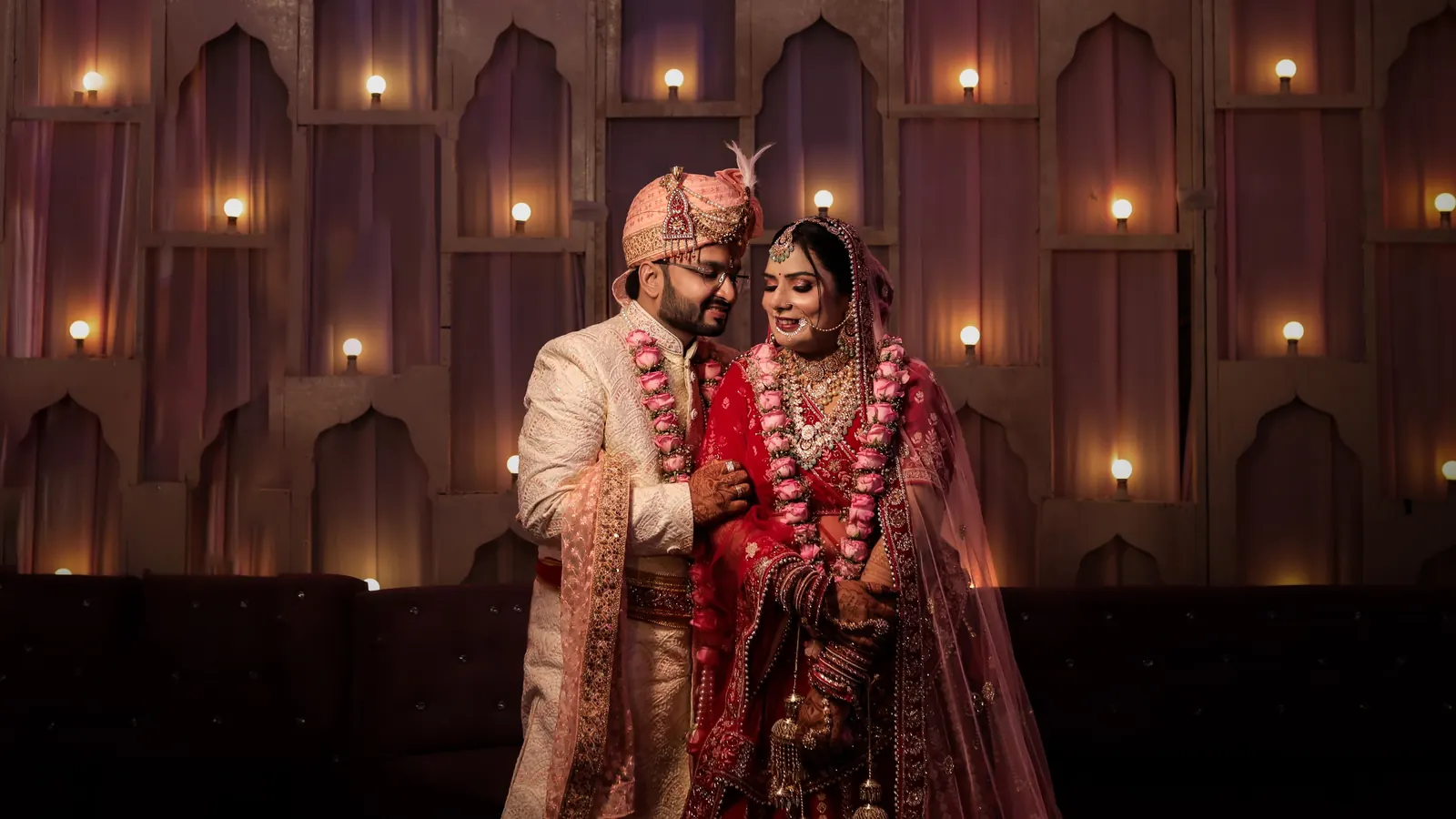 A couple photographed against a wall of candles